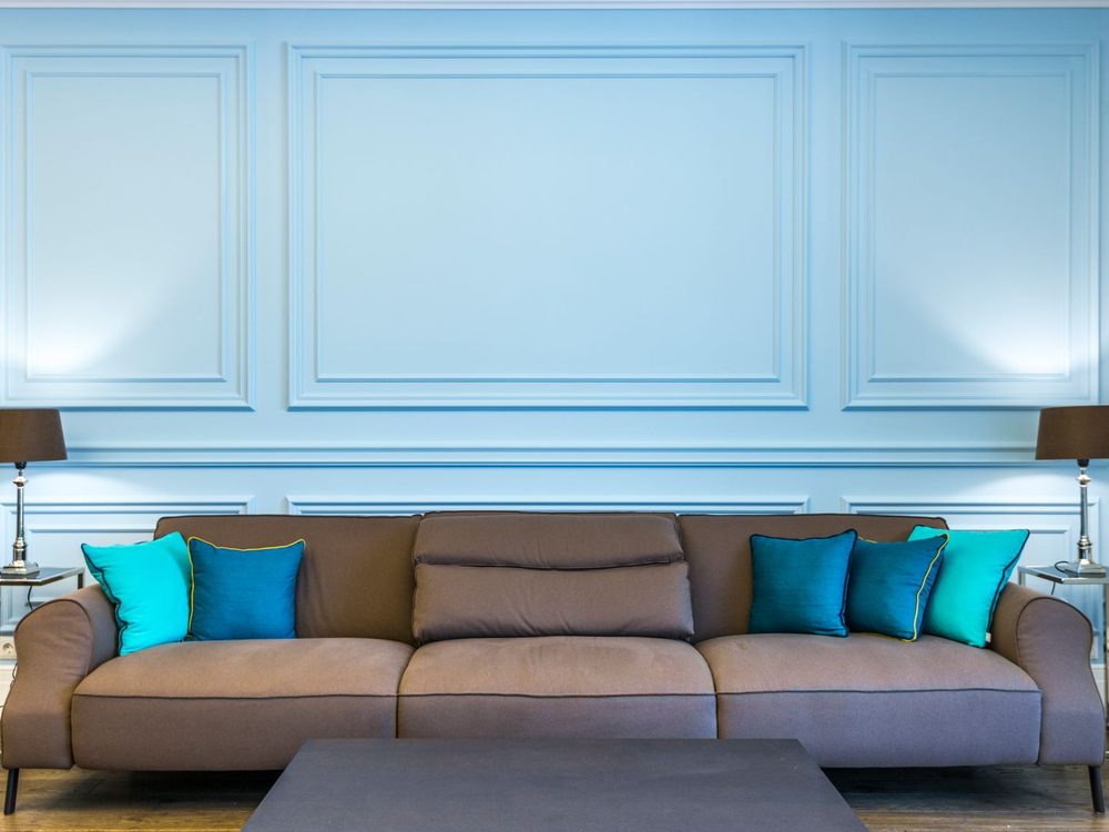 Living room with a soft blue panel-moulded feature wall and crisp white trim