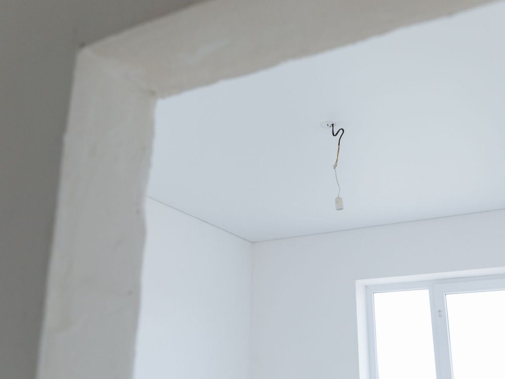 A smooth, freshly finished ceiling meeting a clean painted wall