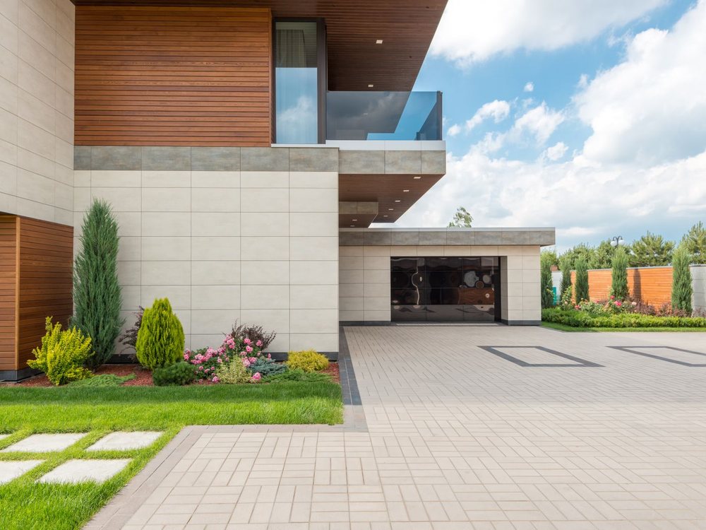A clean paved driveway running up to a modern home